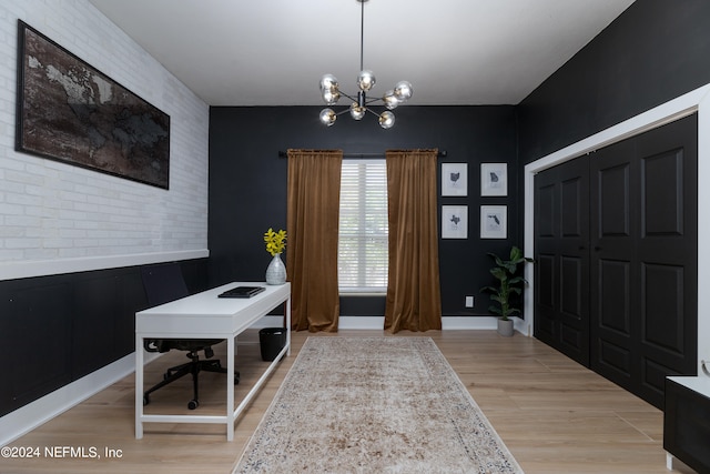 office with an inviting chandelier, brick wall, and light wood-type flooring