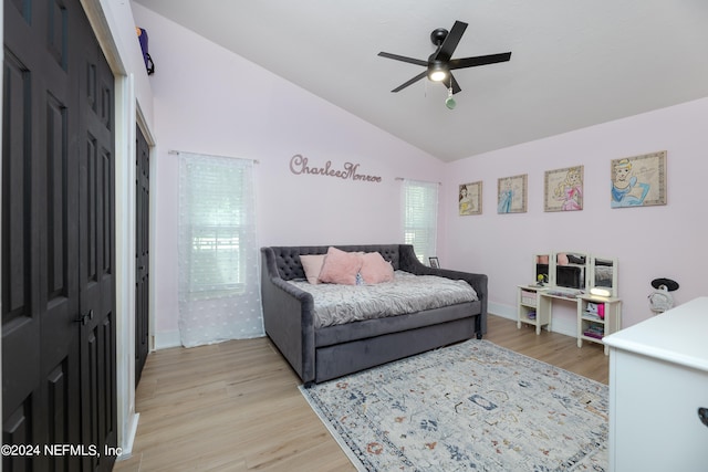 bedroom with a closet, vaulted ceiling, ceiling fan, and light wood-type flooring