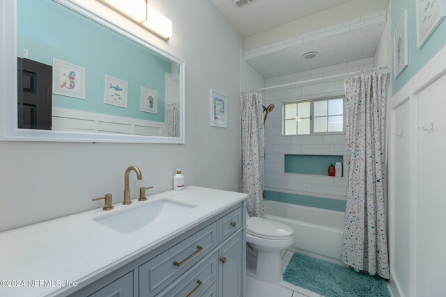 full bathroom with tile floors, toilet, vanity, and shower / bath combo