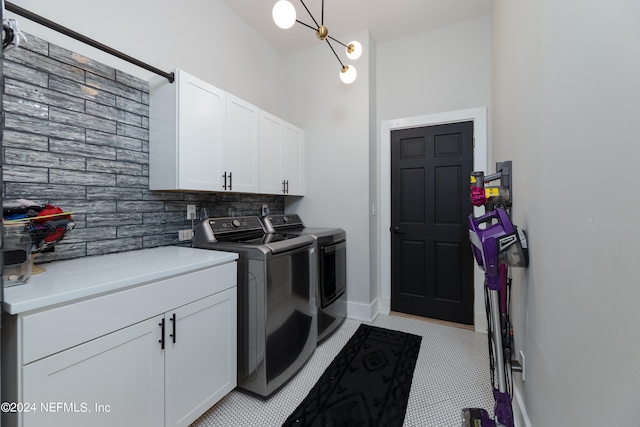 clothes washing area featuring independent washer and dryer, light tile floors, and cabinets