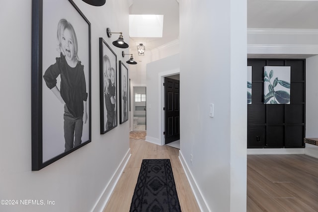 hall with crown molding and light hardwood / wood-style flooring