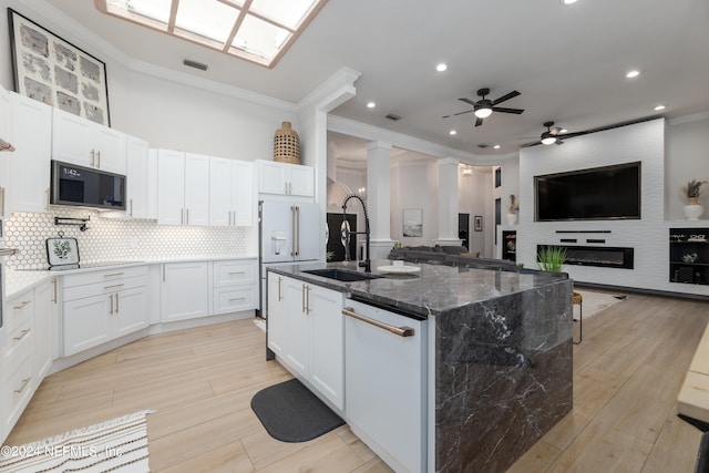 kitchen featuring white cabinets, a large fireplace, and white appliances