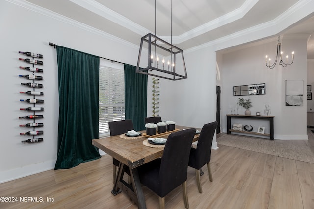 dining area with an inviting chandelier, crown molding, light hardwood / wood-style floors, and a raised ceiling