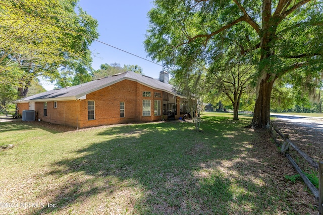 back of house featuring a lawn and central air condition unit