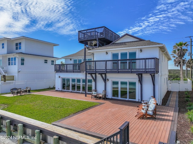 rear view of property with a balcony, a wooden deck, and a patio