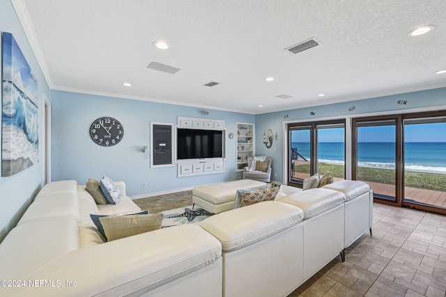 tiled living room featuring crown molding, a water view, and a textured ceiling