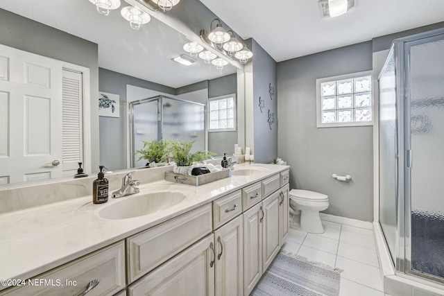 bathroom with toilet, a shower with shower door, double sink, vanity with extensive cabinet space, and tile flooring