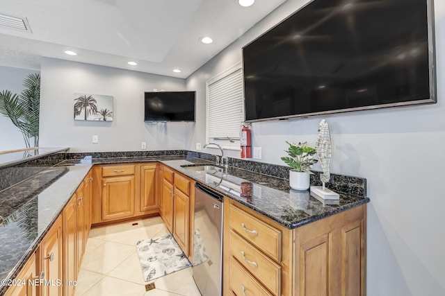 kitchen with light tile floors, dark stone counters, kitchen peninsula, dishwasher, and sink