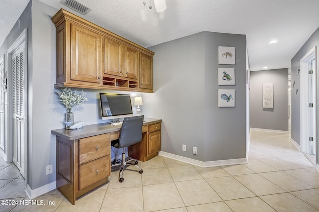 tiled home office featuring a textured ceiling and ceiling fan