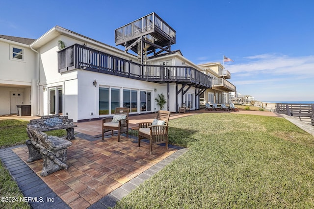 back of house with a yard, a patio area, and a balcony