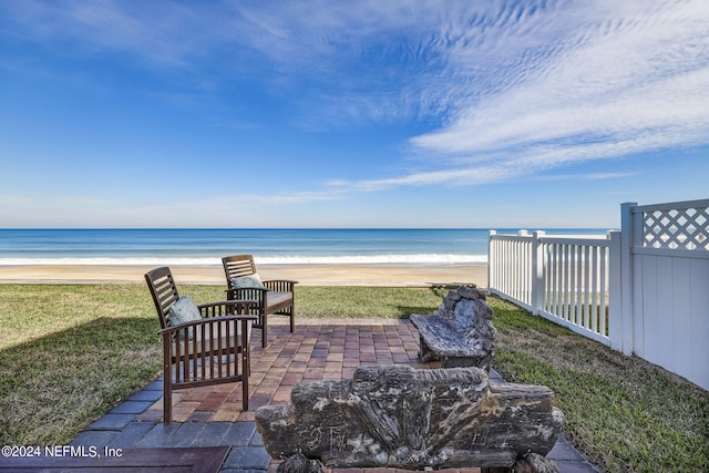 view of patio with a water view and a view of the beach