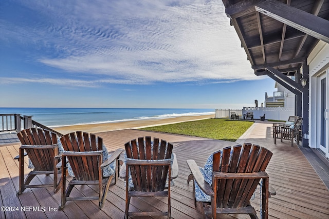 wooden terrace with a water view and a lawn