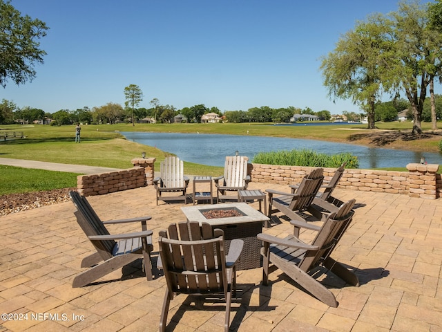 view of patio with a fire pit and a water view