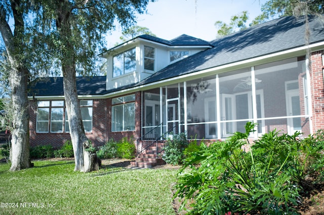 back of house featuring a yard and a sunroom