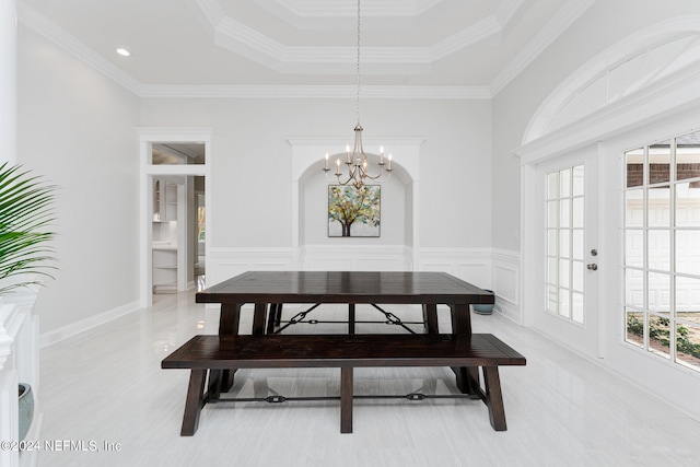 dining room with crown molding, a raised ceiling, and a chandelier