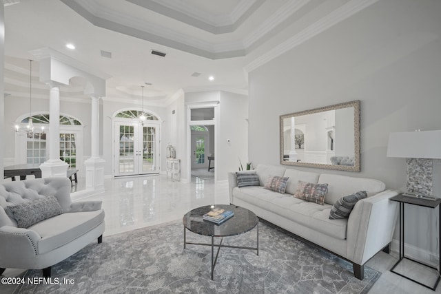 living room featuring ornamental molding, a chandelier, and ornate columns