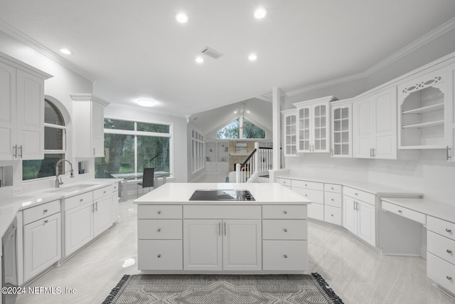 kitchen with white cabinetry, lofted ceiling, black electric stovetop, and a kitchen island