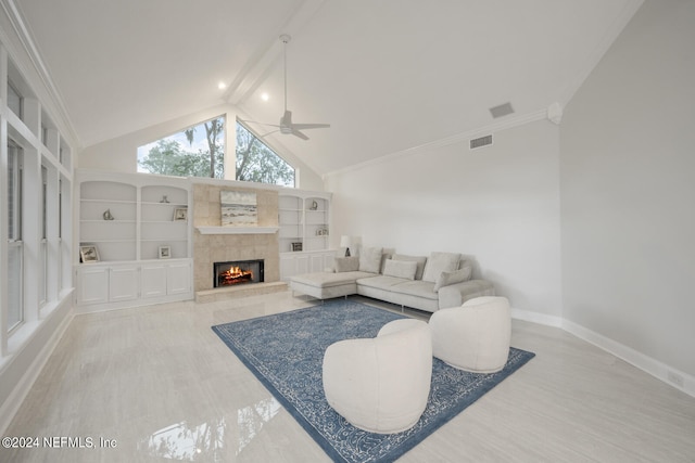 living room with a fireplace, crown molding, light hardwood / wood-style flooring, ceiling fan, and lofted ceiling