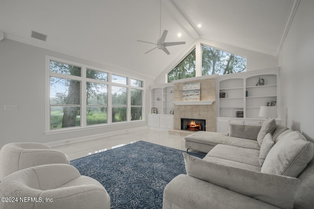 living room with lofted ceiling with beams, plenty of natural light, ceiling fan, and a tile fireplace