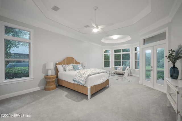 carpeted bedroom with a raised ceiling, ceiling fan, multiple windows, and access to exterior