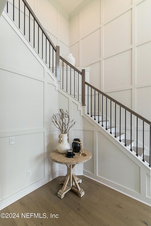 stairs featuring hardwood / wood-style flooring and ornamental molding