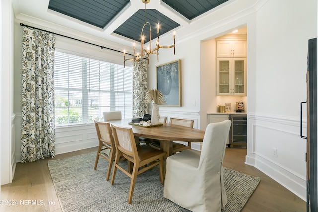 dining space with an inviting chandelier, hardwood / wood-style floors, wine cooler, coffered ceiling, and beamed ceiling