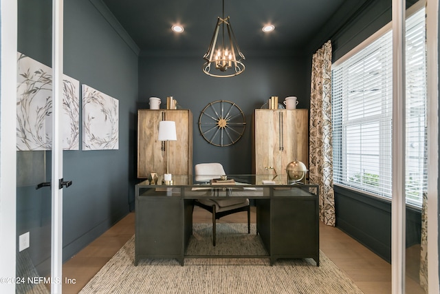 home office featuring an inviting chandelier, crown molding, and light wood-type flooring