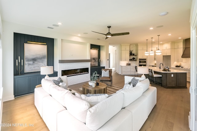 living room featuring light hardwood / wood-style floors and ceiling fan