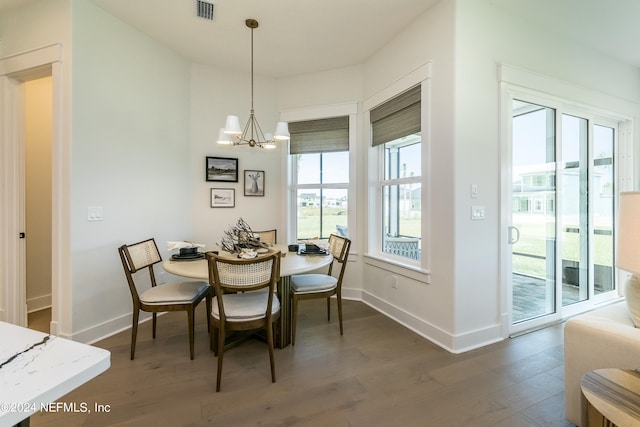 dining area with an inviting chandelier and dark hardwood / wood-style flooring