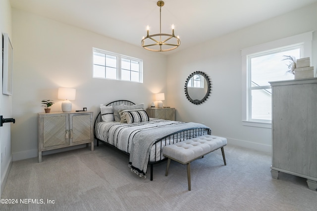 bedroom with a notable chandelier and light colored carpet