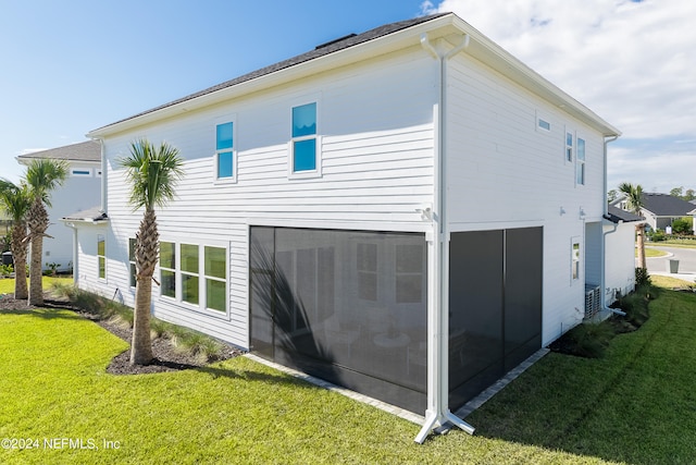 back of house featuring a yard and a sunroom