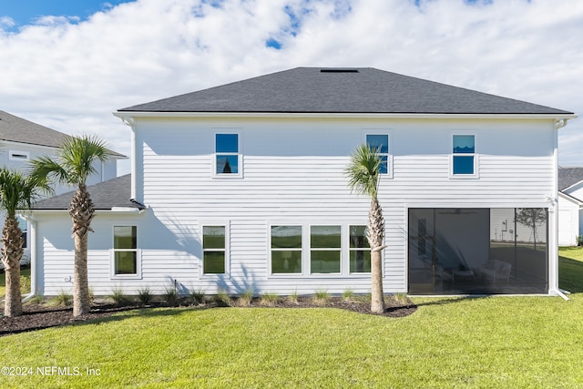 back of house featuring a sunroom and a lawn