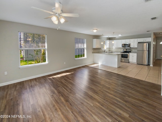 unfurnished living room featuring ceiling fan and light tile flooring