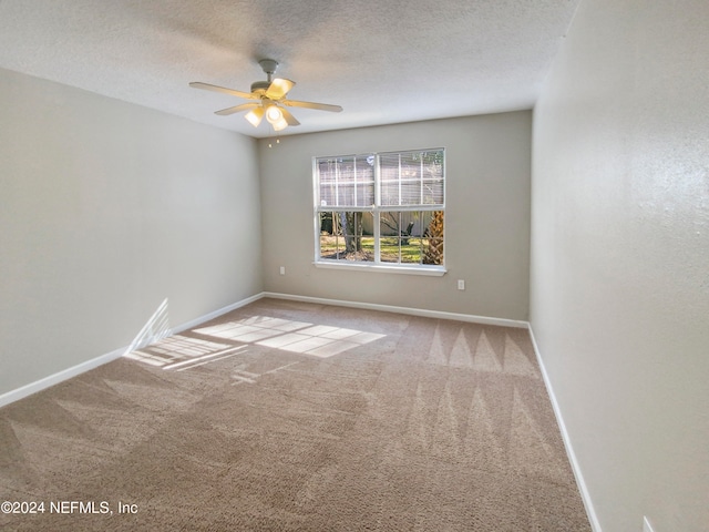 spare room with light colored carpet, ceiling fan, and a textured ceiling