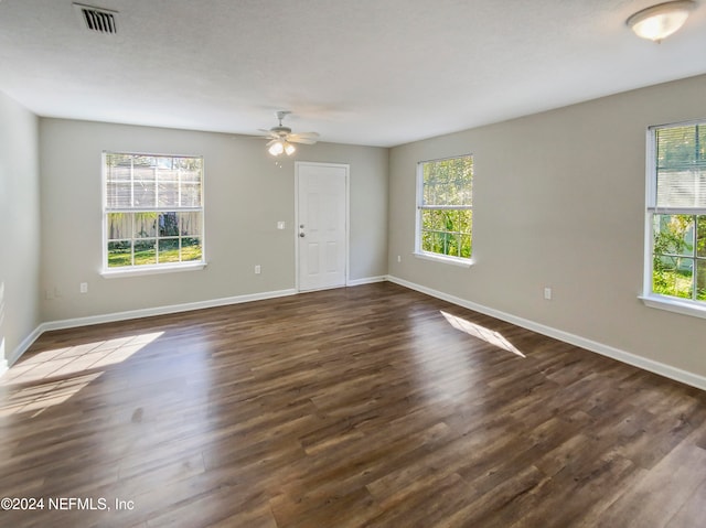 empty room featuring dark hardwood / wood-style flooring, ceiling fan, and a wealth of natural light