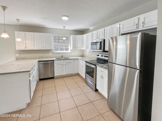 kitchen with light tile flooring, decorative light fixtures, appliances with stainless steel finishes, and sink