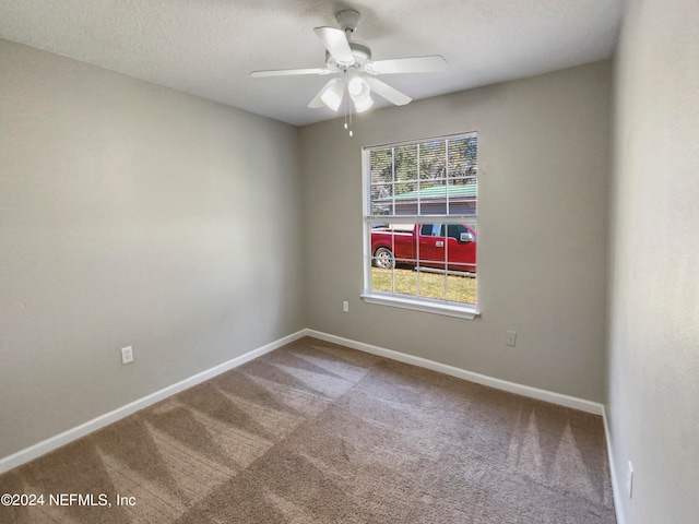 carpeted empty room featuring ceiling fan and a textured ceiling