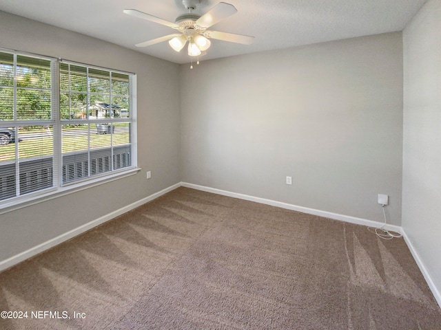 carpeted spare room with ceiling fan