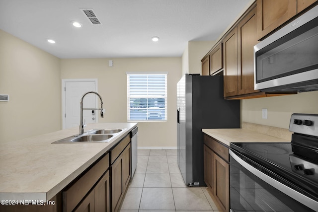 kitchen featuring light tile flooring, sink, and stainless steel appliances