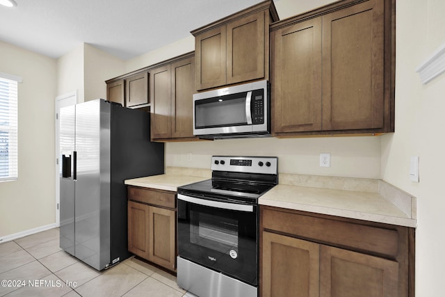 kitchen featuring light tile floors and stainless steel appliances