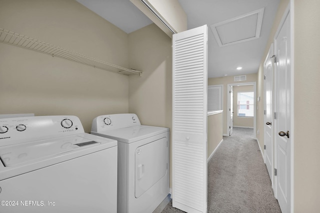 clothes washing area featuring washer and clothes dryer and light colored carpet