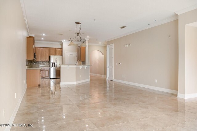 unfurnished living room with ornamental molding and an inviting chandelier