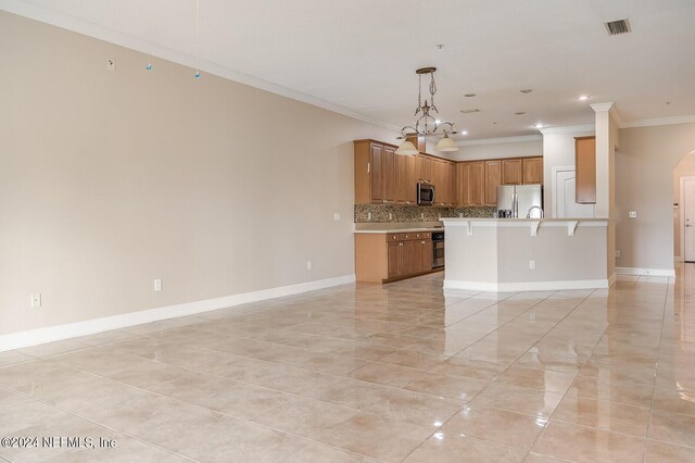 kitchen featuring crown molding, decorative light fixtures, an inviting chandelier, decorative backsplash, and appliances with stainless steel finishes