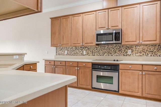 kitchen featuring appliances with stainless steel finishes, tasteful backsplash, and light tile patterned floors