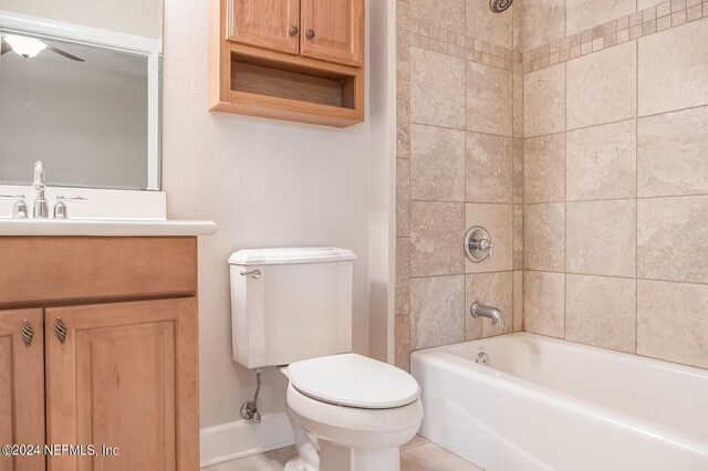 full bathroom featuring toilet, tile patterned floors, vanity, tiled shower / bath combo, and ceiling fan