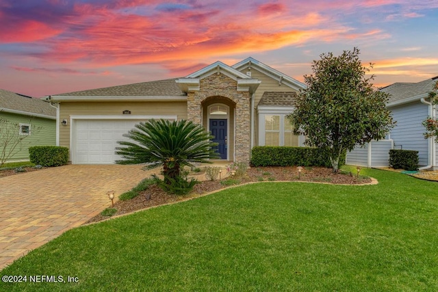 view of front of home featuring a garage and a yard