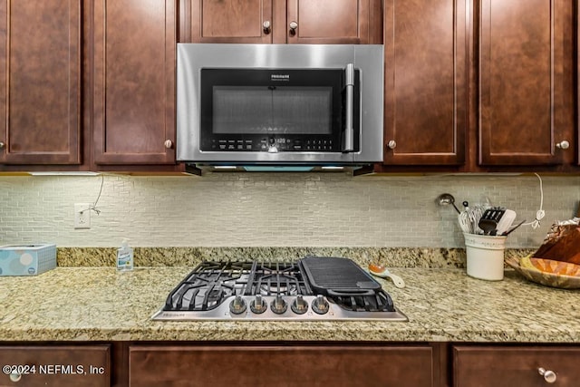 kitchen featuring tasteful backsplash, stainless steel appliances, and light stone countertops