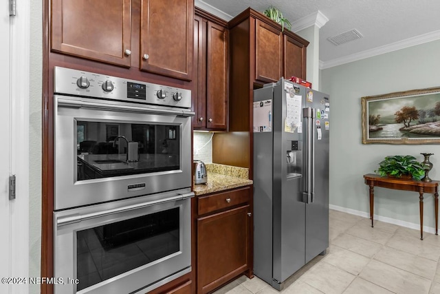 kitchen with appliances with stainless steel finishes, crown molding, light stone countertops, and light tile flooring