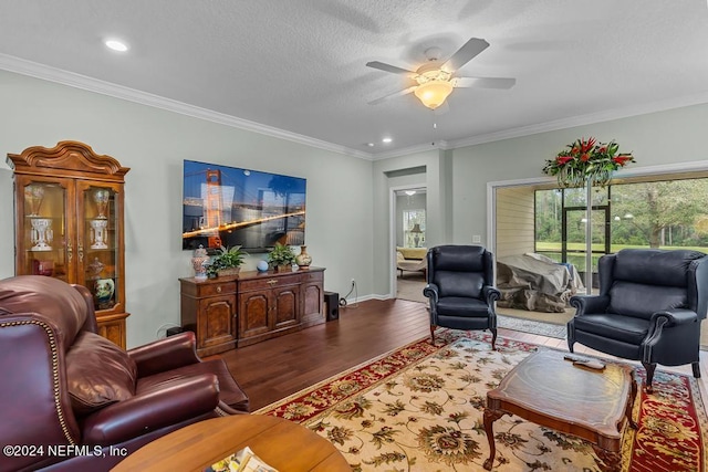 living room with ornamental molding, a textured ceiling, ceiling fan, and dark wood-type flooring