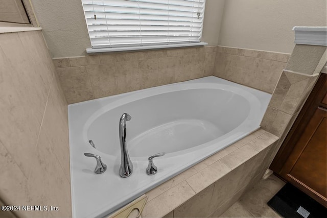 bathroom featuring tiled bath and tile flooring